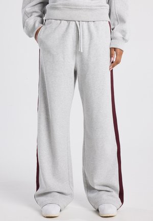 Grijze sweatpants gemaakt van zacht stof, met een relaxed fit, elastische tailleband en bordeauxrode zijkanten voor contrast.