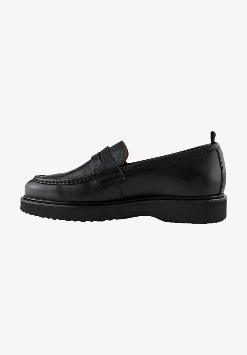 Mocassin en cuir noir avec une semelle épaisse, une couture moc toe et une large bride sur le dessus, vu de profil.