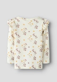 Długi rękaw top w kremowym prążkowanym materiale z pastelowym nadrukiem kwiatowym, w tym żółtymi i fioletowymi kwiatami. Posiada falbany na ramionach.