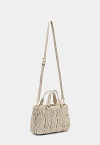 Borsa a mano beige chiaro con texture intrecciata, doppi manici superiori e tracolla regolabile. Presenta dettagli in oro e accenti decorativi.