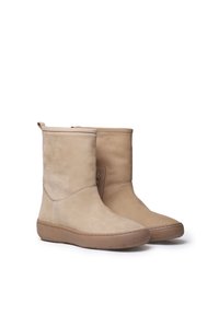 Beige nubukist kõrgsaapad lameda pruuni kummi tallaga, sile tekstuur, ümar nina ja lühike zippdetail külgedel.