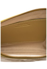 Žuti kožni novčanik iznutra s smešnim tkaninom. Ima teksturiranu površinu, zatvaranje na zip i uvučenu oznaku brenda.