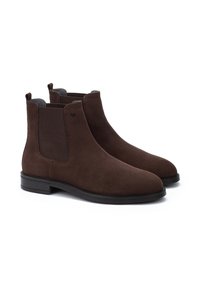 Bottines Chelsea en daim marron avec des panneaux élastiques latéraux, bouts ronds et petites languettes arrière. Elles possèdent une semelle noire plate pour plus de stabilité.