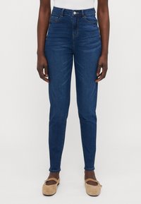 Høyt liv, mørkeblå denimjeans med en glatt tekstur, tettsittende design, to frontlommer, og knapp- og glidelåslukking.
