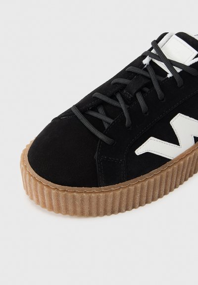 Μαύρο σουέντ αθλητικό παπούτσι με παχιά, ραβδωτή, καουτσούκ σόλα σε απόχρωση φυσικού καουτσούκ και λευκή λεπτομέρεια λογότυπου. Διαθέτει μαύρα κορδόνια και στρογγυλεμένη μύ τη.