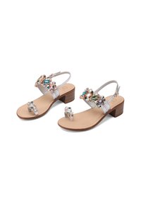 Sandalias de cuero plateado con un bajo tacón cuadrado, que cuentan con adornos de piedras coloridas en la correa y una plantilla texturizada de color beige.