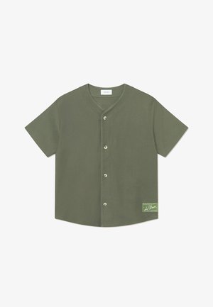 Camicetta verde oliva a maniche corte con scollo a V, dotata di cinque bottoni e un'etichetta rettangolare sul lato sinistro. Texture liscia.