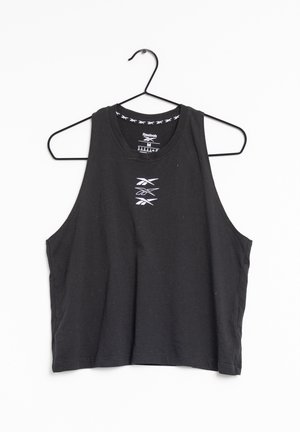 Crop top noir sans manches Reebok avec logo blanc centré sur la poitrine, suspendu sur un cintre métallique noir sur fond blanc.