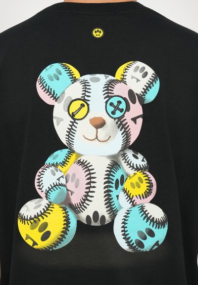 Juodas džemperis su spalvinga meškos dizaino iliustracija, išsiskiriantis siuvinėjimo raštais ir mygtukais geltonos, rožinės ir mėlynos spalvų atspalviuose.