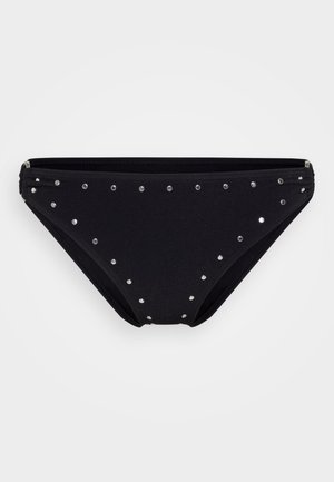 Fekete bikini alsó, textúrált anyagból, ezüsttűkkel egyenletesen elhelyezve a felületen, a részletek fokozása érdekében.