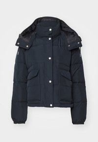 Marinblå puffjacka med hög krage, tryckknappar och två framfickor. Har elastiska ärmslut och en avtagbar huva.