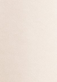 Texture de tissu beige avec des fils fins et étroitement tissés formant une surface lisse et uniforme.