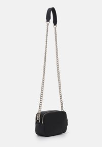 Borsa a tracolla nera in materiale sintetico con forma rettangolare, dotata di una tracolla a catena in argento e chiusura con zip. Texture liscia, design minimal.