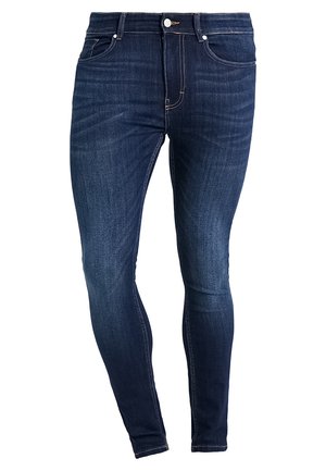 Jeans de denim azul oscuro con un diseño ajustado, estilo de cinco bolsillos y detalles de costura en contraste. El material parece suave con una ligera textura.