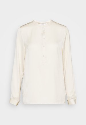 Long-sleeve, cream-colored blouse in smooth fabric. Features a round neck, front placket with buttons, and buttoned cuffs. Simple design.