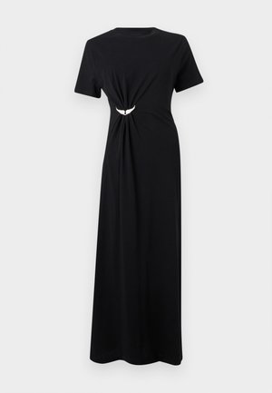 Robe longue noire à manches courtes avec encolure ronde, fronces latérales rassemblées par une petite broche blanche en forme d'aile à la taille.
