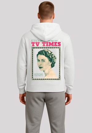 Man wearing white hoodie with vintage TV Times magazine cover showing a portrait of a woman with styled hair on the back.