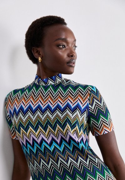 Abito a maniche corte con un motivo a zigzag multicolore che presenta verde, blu, arancione e nero. Design a collo alto con tessuto strutturato.