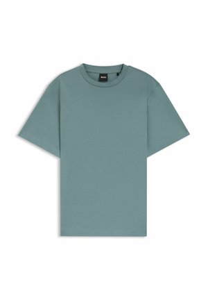 Camiseta de manga corta hecha de algodón suave en un color verde azulado apagado. Presenta un cuello redondo y un corte relajado. Etiqueta visible en el cuello.