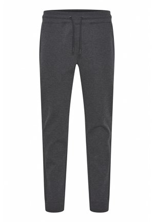 Mørkegrå joggebukser laget av et mykt, elastisk stoff. Har elastisk midjebånd med snor og stikninger med ribbestrikkede mansjetter.