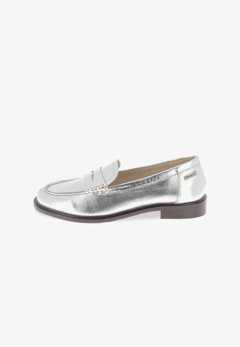 Mocasines de cuero plateado con suela plana marrón, que cuentan con un borde cosido y una pequeña correa decorativa en la parte frontal.