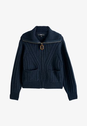 Marineblauwe gebreide cardigan met geribbelde textuur, ritssluiting aan de voorkant met bruine ovale trekker, brede kraag en twee voorzakken.