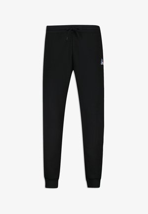 Pantalones de chándal negros hechos de una tela suave, con una cinturilla elástica y un cordón, puños en los tobillos y un pequeño logo como acento.