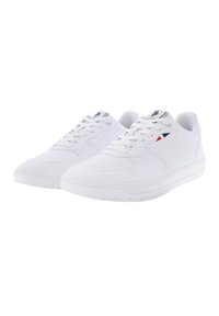 Sneakers bianchi in materiale sintetico con design perforato, lacci piatti e una suola in gomma testurizzata con sottili accenti di branding.
