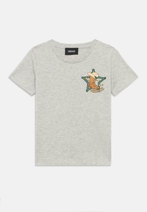 Camiseta gris claro de manga corta con un gráfico de bota de vaquero y sombrero dentro de una estrella de sheriff verde en el pecho, etiquetada como "Versace."