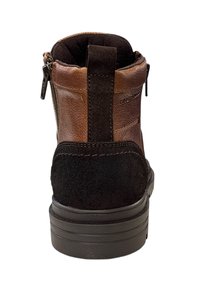 Bruine en zwarte leren laars met een zijrits en een trekband, van achteraf gezien op een witte achtergrond.