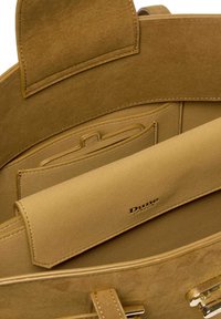 Suede handbag in beige with smooth interior, featuring a fold-over flap, multiple pockets, and embossed logo for brand identification.
