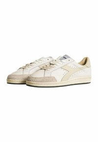 Scarpe da tennis bianche in pelle con dettagli in suede beige, dotate di una punta testurizzata, un design perforato e un interno imbottito. Suola in gomma nera.