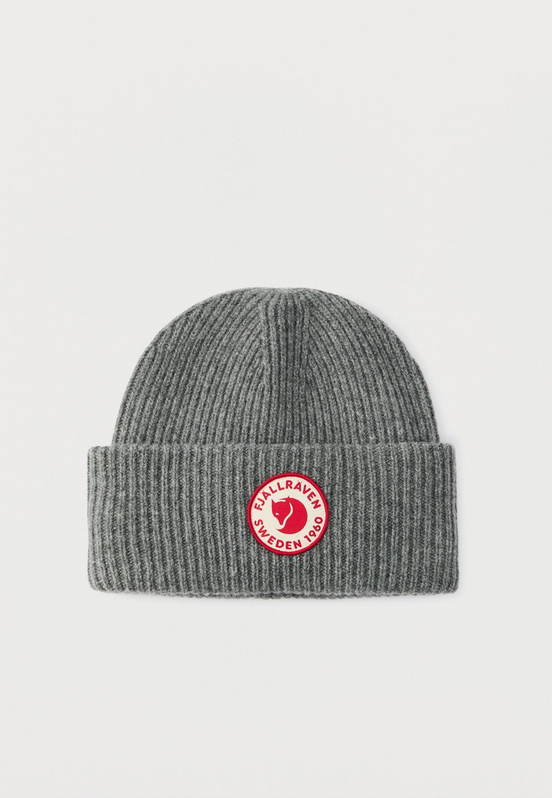 Gorro de punto gris con textura acanalada y puño doblado. Presenta un parche circular rojo con un logo y texto, centrado en la parte frontal.