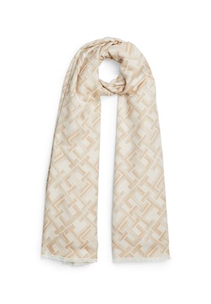 Jasnobeżowy szalik z geometrycznym, przeplatającym się wzorem w ciemniejszych beżowych odcieniach, zawieszony na pętli u góry.