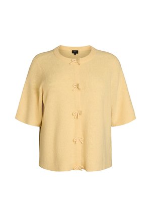 Kratka, bledo rumena jopica iz teksturirane tkanine z okroglim izrezom in petimi sprednjimi zapenjalmi, ki so zavezani s pentljami.