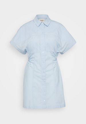 Rochie din bumbac, de culoare bleu deschis, cu mâneci scurte, închidere cu nasturi, guler și drapaj subtil pe laterale pentru o siluetă ajustată.