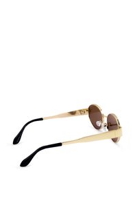 Złote okulary przeciwsłoneczne z okrągłymi brązowymi soczewkami. Smukłe zauszniki o matowym wykończeniu. Posiadają przezroczyste podkładki na nos i czarne końcówki zausznika.