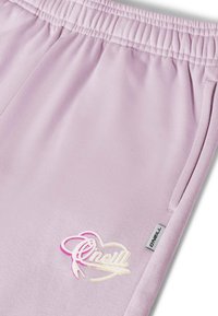 Lila joggingbroek met een elastische tailleband, voorzien van een glanzend "O'Neill"-logo in roze en goud, gestikte zakken en een zachte textuur.