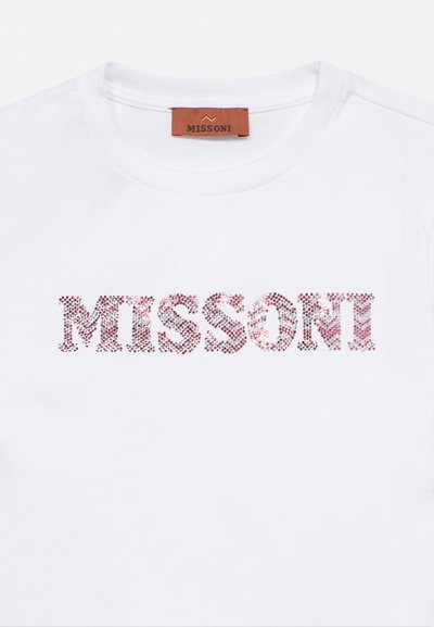 Λευκό βαμβακερό t-shirt με στρογγυλή λαιμόκοψη που φέρει τη λέξη "MISSONI" με ροζ γράμματα από γκλίτερ. Η ετικέτα στο πίσω μέρος είναι από καφέ δέρμα.