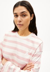 Sweatshirt léger à manches longues, à rayures roses et blanches, avec un col rond et un accent brodé sur la poitrine.
