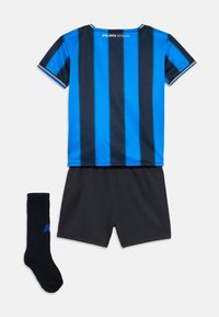 Zilā un melnā vertikāli svītrota futbola krekls ar uzrakstu Atalanta Bergamo, melnas bikses un melnas zeķes ar zilu logo uz balta fona.