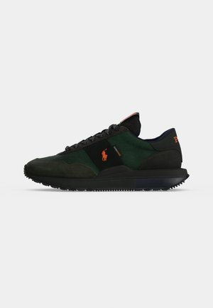 Baskets noires et vert foncé à profil bas avec logo Polo orange, lacets noirs et semelle en caoutchouc texturée, vue de côté sur fond gris clair.
