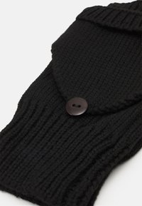 Zwarte gebreide accessoire met ribbelstructuur, voorzien van een klep en een ronde knoopdetail. Zacht materiaal met een snug fit voor warmte.