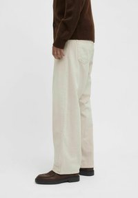 Light beige wide-leg pants with a relaxed fit, made of denim, featuring a classic five-pocket design and visible stitching details.