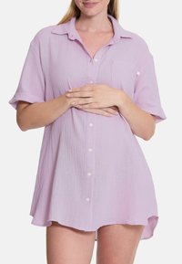 Lichtpaarse button-up shirt gemaakt van gestructureerde stof. Bevat korte mouwen, een kraag en een borstzak. De zoom is licht gebogen.