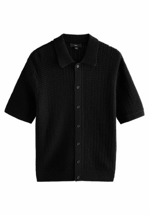 Cardigan tricotat cu mânecă scurtă, de culoare neagră, cu o țesătură texturată, închidere cu butoni și guler și tiv cu benzi elastice. Are șase butoane pe față.
