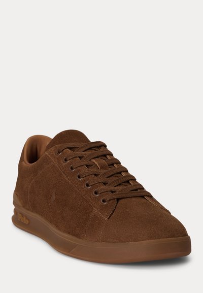 Καφέ σουέντ sneakers με κορδόνια και λαστιχένια σόλα, με διακριτικό ανάγλυφο λογότυπο στο πλάι, γωνιώδης για να δείχνει το μπροστινό και εξωτερικό μέρος.