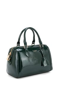 Sac à main en simili cuir vert foncé brillant, de forme arrondie, avec poignées doubles, quincaillerie dorée et fermeture éclair. Comprend un pompon décoratif et le logo de la marque.
