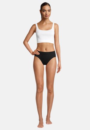 Weißes Baumwoll-Crop-Top mit breiten Trägern, kombiniert mit schwarzen hochgeschnittenen Unterhosen. Glatte Textur, minimalistisches Design und keine sichtbaren Muster.