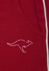 Red fabric featuring a kangaroo logo in white outline, smooth texture with fine knit pattern, and small pocket on the side.
